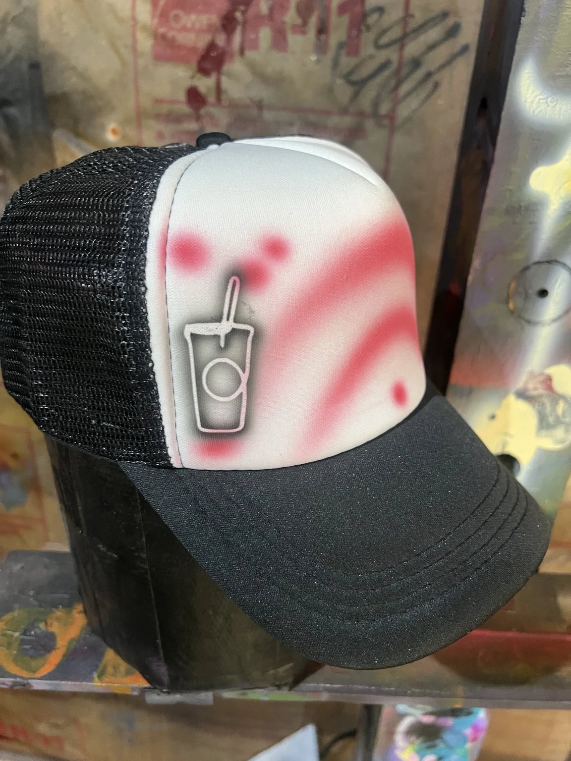 Black trucker hat with a coffee cup design and red airbrush shading for 7 Brew in Nashville