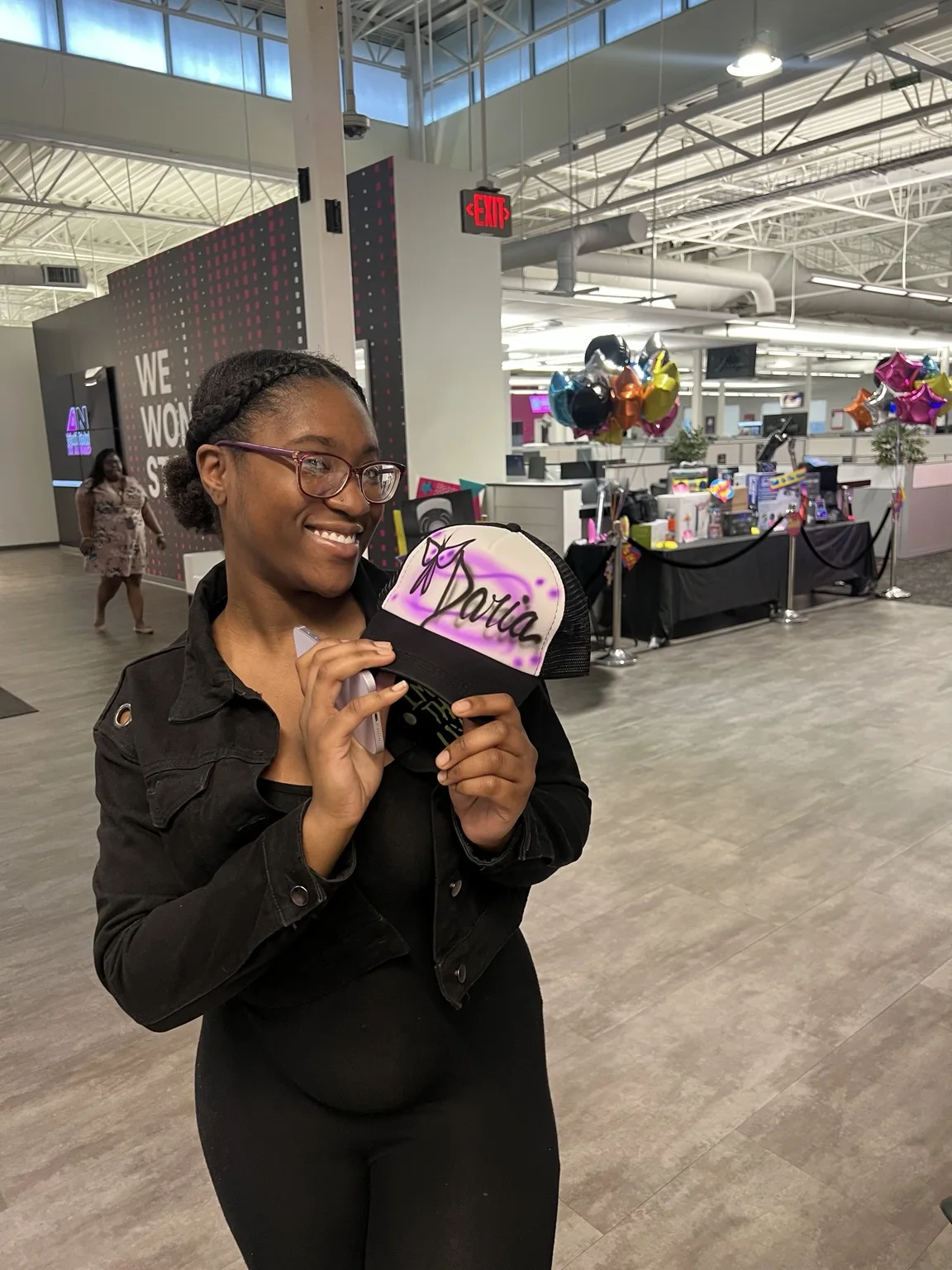 Guest holding a pink and black custom airbrush hat at the T-Mobile event in Augusta