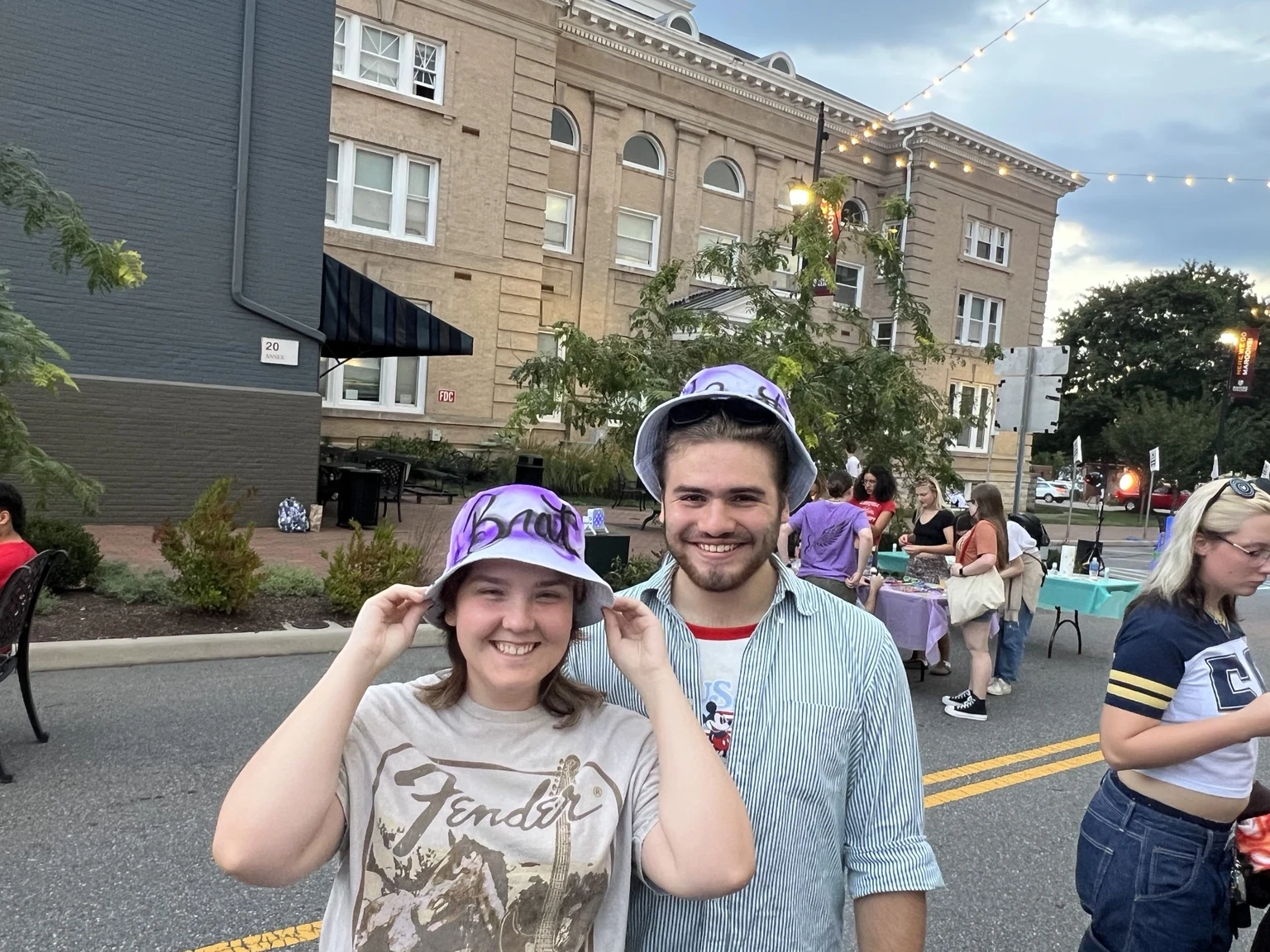 Roanoke College student wearing a personalized purple airbrushed bucket hat at the Fall Festival